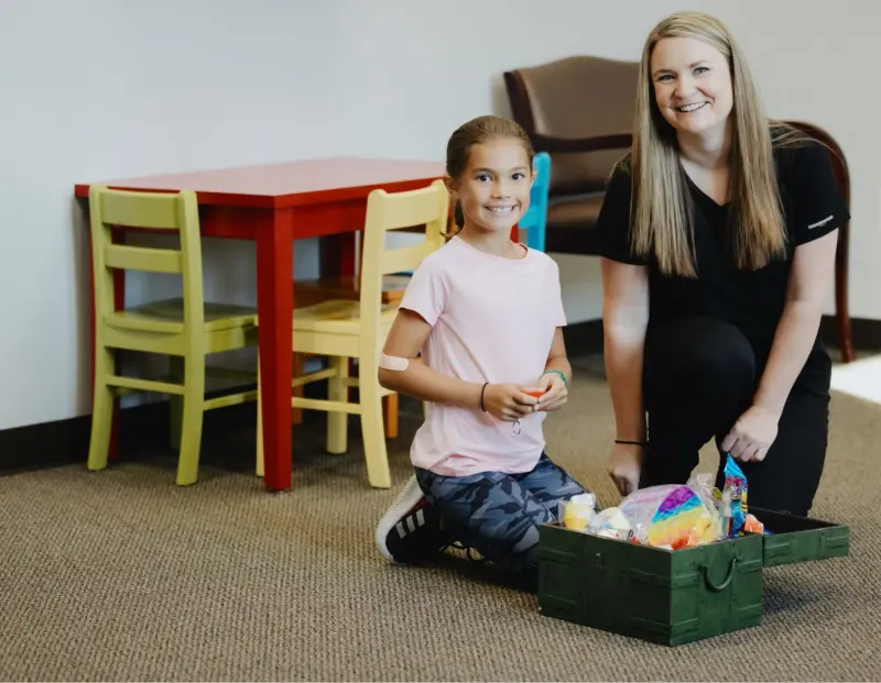 A Hilltop team member playing with a young patient in the children’s corner