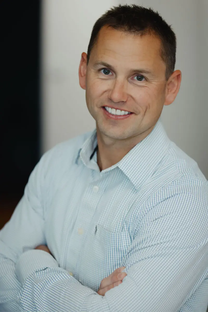 Dr. David Gallup in a white shirt, smiling, at Hilltop Family Dental